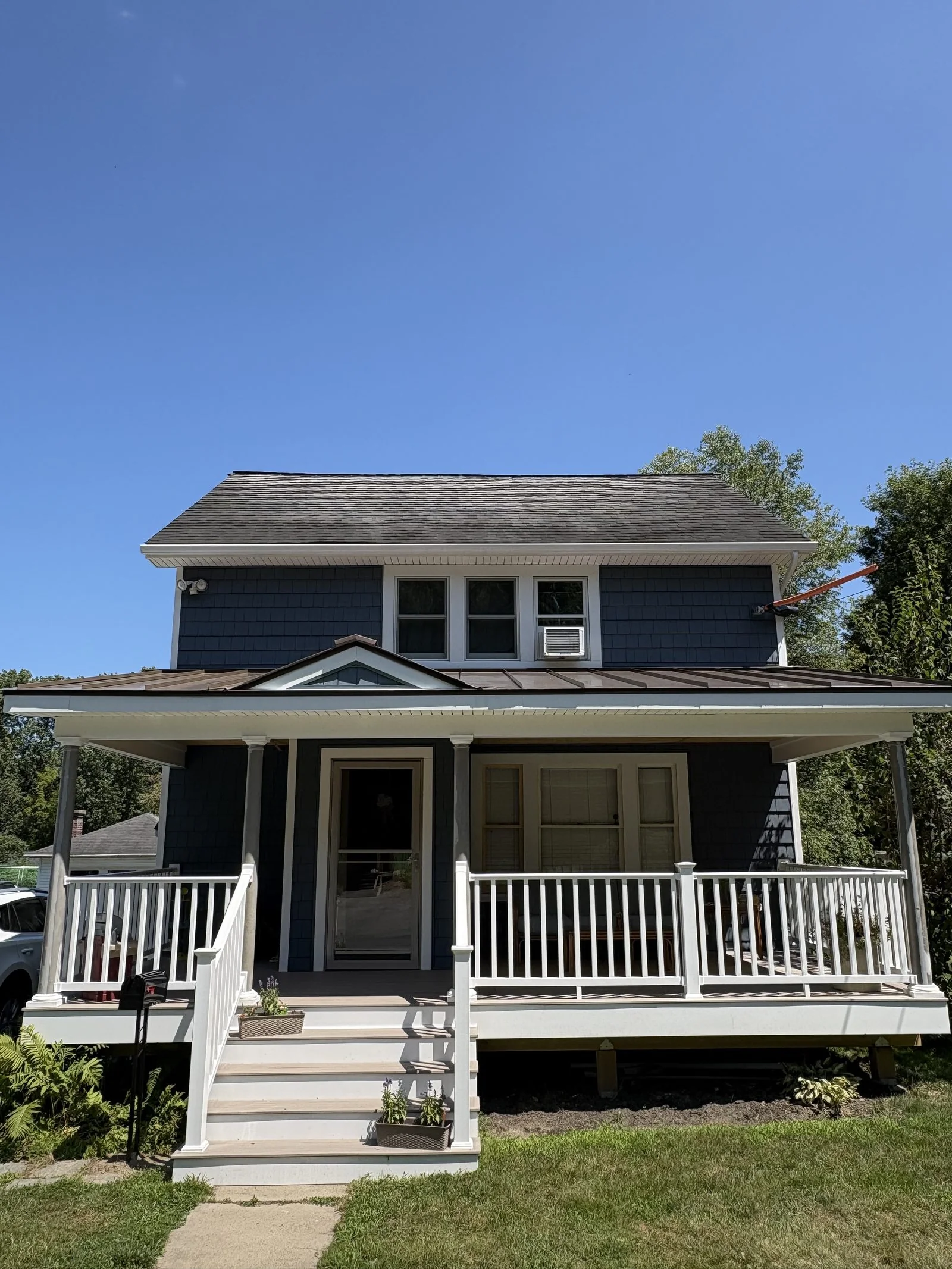 Home with blue siding and a covered front porch