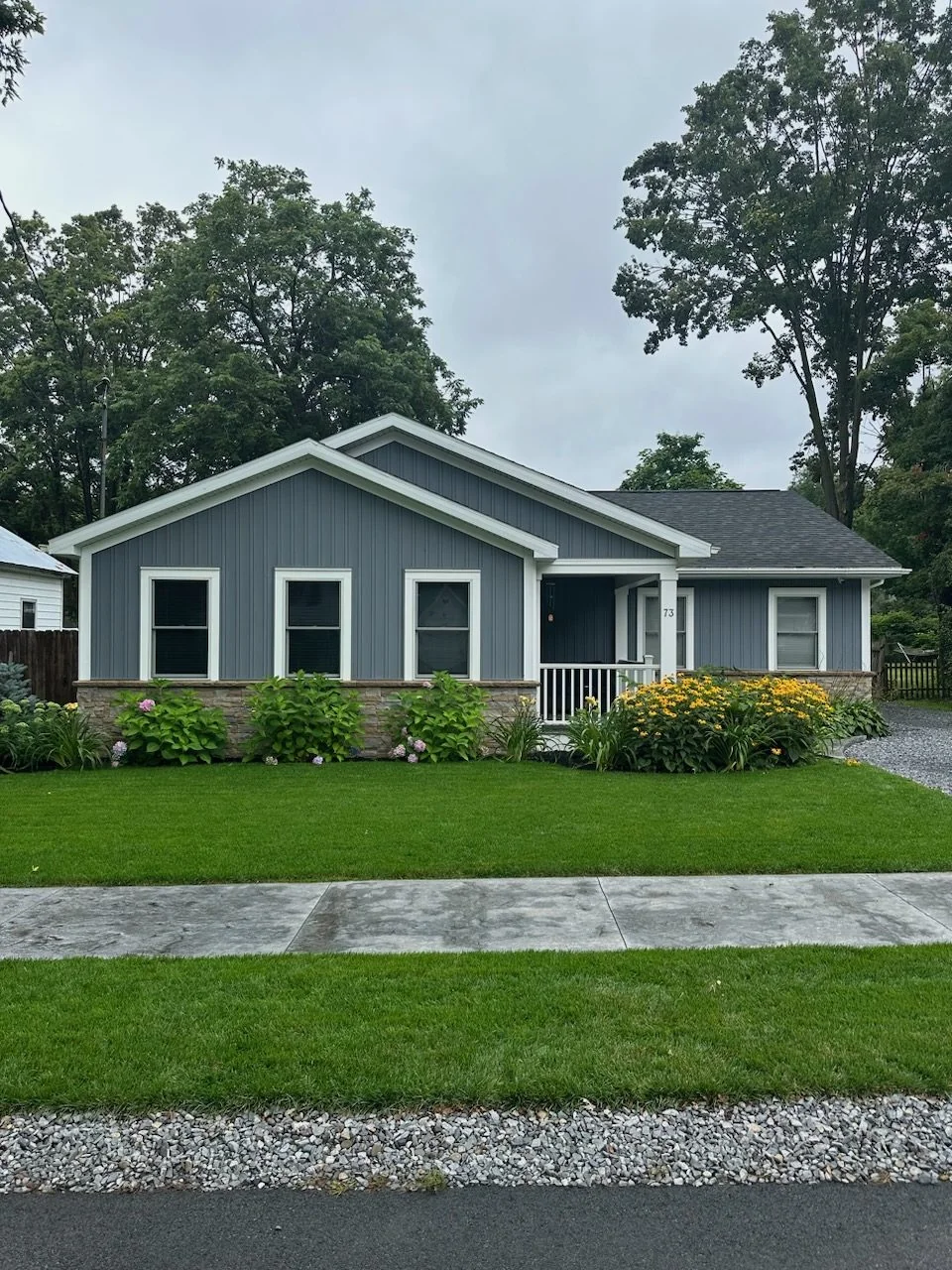 Ranch home with fresh gray siding and landscaped lawn