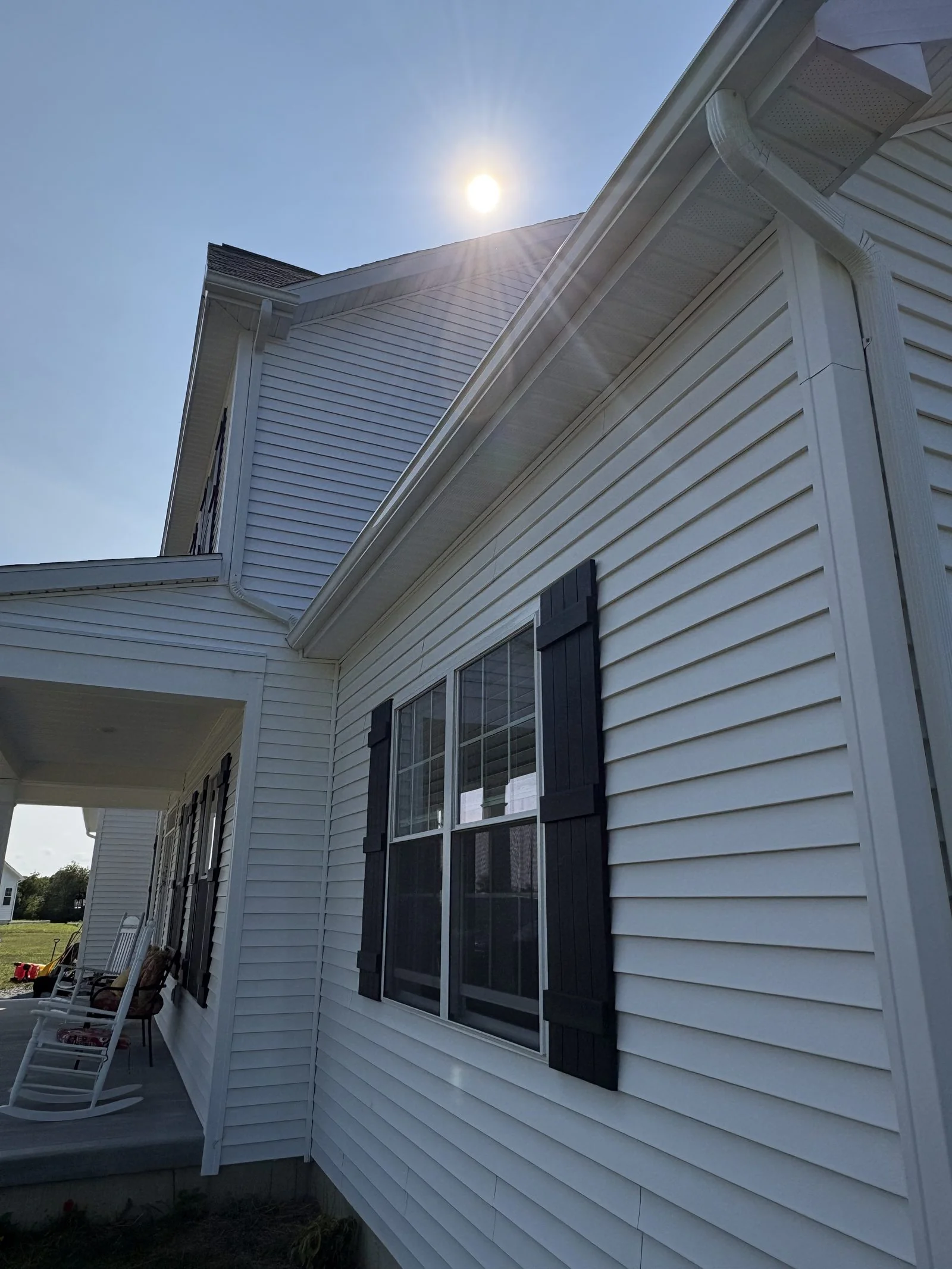 White siding with black shutters on a two-story home